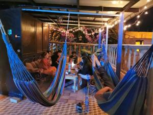 a group of people sitting in hammocks in a restaurant at Surf hostel Morocco in Tamraght Ouzdar