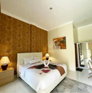 a bedroom with a large white bed and a window at Djembar Inn in Kalasan
