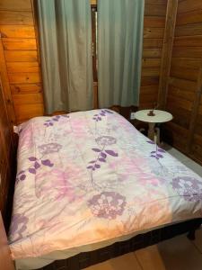 a bed with a pink comforter and a table at Casa de Campo Rio Miguel in Aguas Mornas +41 photos