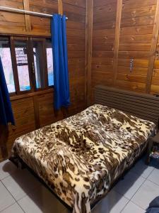 a bed in a room with wooden walls at Casa de Campo Rio Miguel in Aguas Mornas