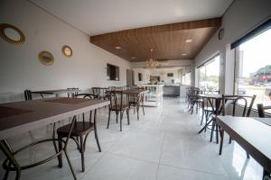 a restaurant with tables and chairs in a room at Hotel Monte Carlo in Dourados