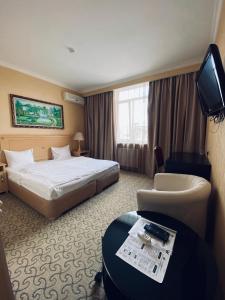 um quarto de hotel com uma cama e uma televisão em Sunflow Park Hotel em Kartmazovo