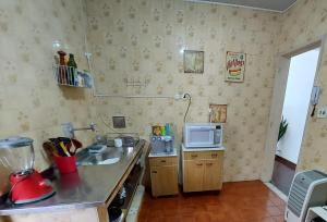 a small kitchen with a sink and a microwave at Quarto tranquilo e familiar no leblon - Quiet family room in leblon in Rio de Janeiro