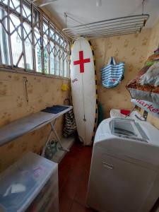 a surfboard sitting in a room with a washing machine at Quarto tranquilo e familiar no leblon - Quiet family room in leblon in Rio de Janeiro
