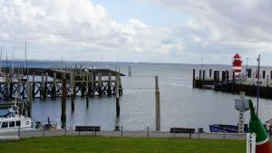 ein Dock mit einem roten und weißen Leuchtturm im Wasser in der Unterkunft Haus Gud Hööb Whg 02 in Wyk auf Föhr