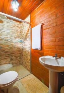 een badkamer met een toilet, een wastafel en een douche bij Cabanas Mountain in Campos do Jordão