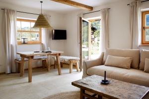 a living room with a couch and a table at Der Schmiedhof in Bayrischzell