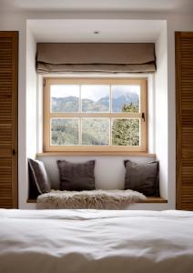 a window in a room with a bed and a window seat at Der Schmiedhof in Bayrischzell
