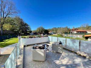 uma varanda com cadeiras, uma cerca e um campo em Akla Hotel Suites Valles Pasiegos em Saro