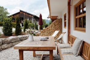 a patio with a wooden table and chairs at Der Schmiedhof in Bayrischzell