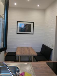 uma cozinha com uma mesa e uma televisão na parede em Bungalow 451 in Tossens em Tossens