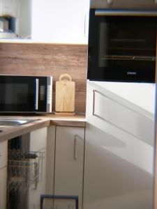 a kitchen with a microwave oven and a stove at Bungalow 451 in Tossens in Butjadingen OT Tossens