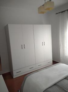 1 dormitorio blanco con 1 cama y armarios blancos en Casa iluminada en pueblo tranquilo, en Jedula