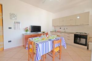 une cuisine avec une table avec un chiffon bleu et blanc dans l'établissement Lorinne Vista Mare Torre Vado, à Torre Vado