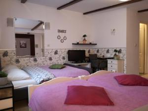 ザグレブにあるルームズ マディソンの紫のシーツが備わる客室内のベッド2台