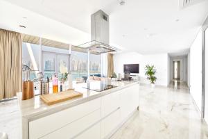 a kitchen with white cabinets and a large window at Contemporary and Spacious 2 BR in Bluewaters Island in Dubai