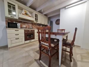 eine Küche mit einem Holztisch und 2 Stühlen in der Unterkunft Flat 24 Maggio in Lecce