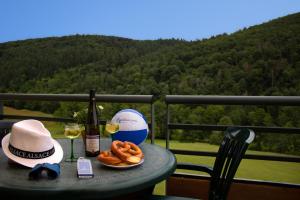 un tavolo con una bottiglia di vino e un piatto di pretzel di Goélia Le Domaine du Golf ad Ammerschwihr