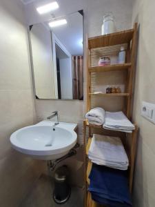 ein Badezimmer mit einem Waschbecken, einem Spiegel und Handtüchern in der Unterkunft Flat 24 Maggio in Lecce