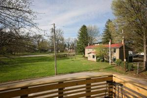 una valla de madera frente a un patio con una casa en Park Carriage House Rest & Explore with Hollyhock en Louisville