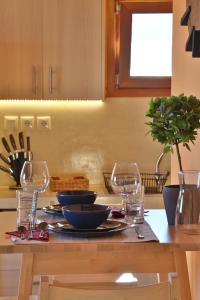 a table with glasses and plates of food on it at Picollo Grecia Residence Panoramic View in Ermoupoli
