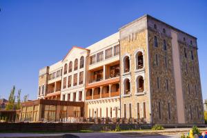 un grand bâtiment en briques avec de nombreuses fenêtres. dans l'établissement Caucasus Hotel, à Erevan