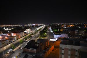 uitzicht op een stad 's nachts met verlichting bij Florida Inn Hotel in Najran