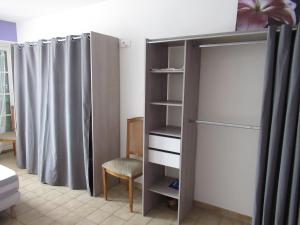 um quarto com um closet com uma cama e uma cadeira em maison ancienne rénovée tout confort em Narcy