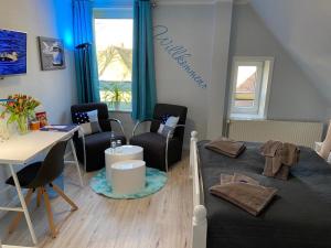 ein Wohnzimmer mit einem Tisch, Stühlen und einem Schreibtisch in der Unterkunft Friesenhof Nieblum - Hotel Garni in Nieblum