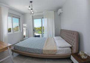 a bedroom with a large bed with a large window at SERENITY HOUSE in Nafplio +122 photos