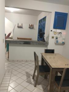 uma cozinha com mesa e cadeiras e um balcão em Porto Canoa próximo a praia Canoa Quebrada Apto 111 Creta Aracati CE em Aracati