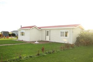a small white house with a yard at Panorama Chalet in Drijber