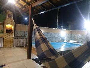 a hammock in front of a swimming pool at night at Meu lugar de Descanso in Cabo Frio