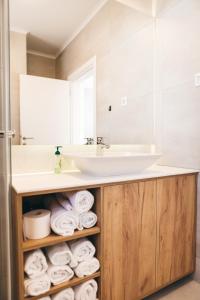 a bathroom with a sink and a pile of towels at olive tree house in Mostar