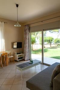 a living room with a couch and a tv at Brunello Seaside Apartments in Lefkada Town