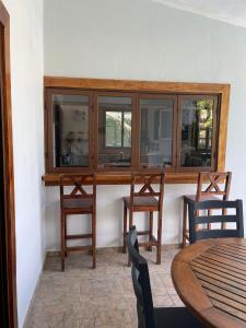 a dining room with wooden cabinets and a table and chairs at Casa Piscina in Santa Teresa Beach