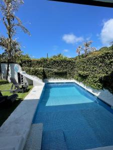 a swimming pool in front of a hill with at Casa Piscina in Santa Teresa Beach