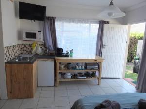 a kitchen with a sink and a counter top at Heron Place sunny self-catering garden flatlet in Port Alfred