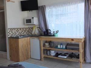 a kitchen with a table and a sink and a window at Heron Place sunny self-catering garden flatlet in Port Alfred