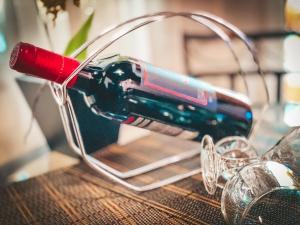 a wine bottle holder sitting on a table with glasses at Pousada Flor de Ipe in São Bento do Sapucaí
