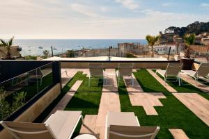 Un balcón con sillas y vistas al océano. en Hotel Delfín, en Tossa de Mar