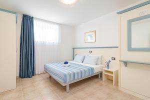 a bedroom with a bed with a blue and white blanket at Residence Kamenjak in Premantura