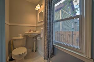 baño con aseo y lavabo y ventana en Manistee House with Deck, Fire Pit and Sunroom!, en Manistee