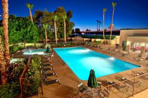 een groot zwembad met stoelen en parasols bij Independence 47 Hotel in Scottsdale