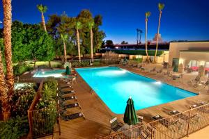 a large swimming pool with chairs and umbrellas at Independence 47 Hotel in Scottsdale