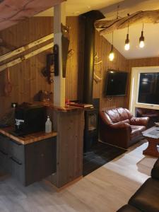 a living room with wood paneled walls and a television at Finnvikhaugen Rooms in Meistervik