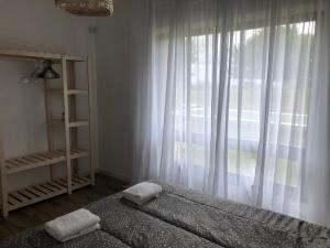 Casa de campo DON ANTONIO في سان بيدرو: غرفة نوم بسرير ونافذة ذات ستائر بيضاء