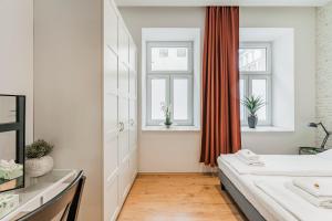 sypialnia z łóżkiem i dwoma oknami w obiekcie ZEUS Design Apartments Herz w Wiedniu