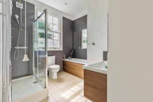 a bathroom with a shower and a toilet and a sink at Camden Home - Barracks Properties in London