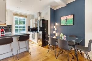 a kitchen and dining room with a table and chairs at Camden Home - Barracks Properties in London